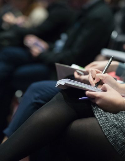 selective focus photography of people sitting on chairs while writing on notebooks